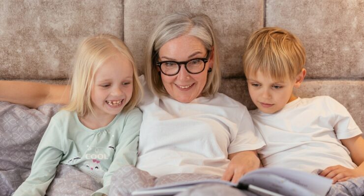 Dzieci czytające książkę wraz z babcią.